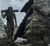 A Ukrainian soldier carries supplies in a trench at the frontline near Bakhmut in the Donetsk region, Ukraine, Monday, May 22, 2023. (AP Photo/Libkos)